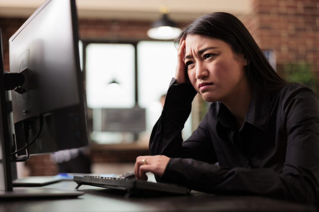 Tired tech engineer was struggling to keep up with the demands of the software development project, feeling the stress of overwork. Coder writing ai algorithm and sitting at desk in it company.